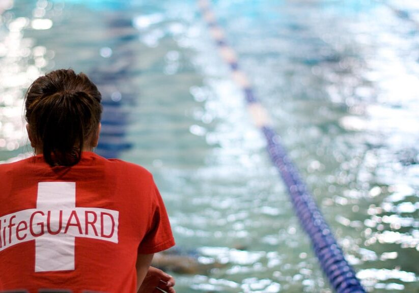 a lifeguard sits next to the pool