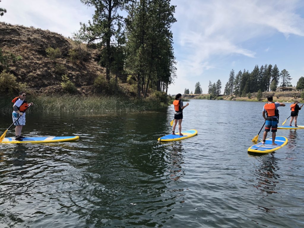 students paddleboarding on lake