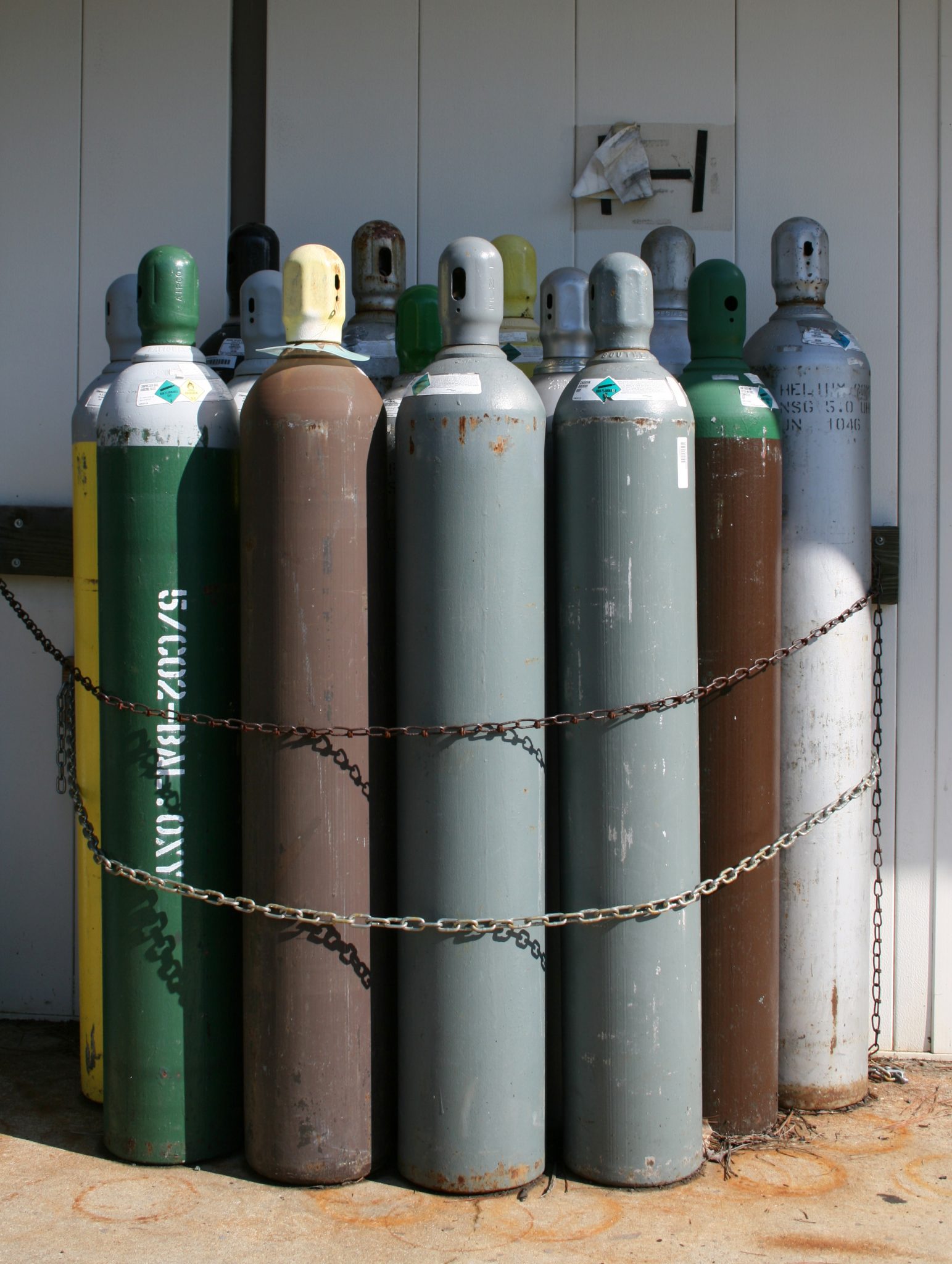 Compressed gas cylinders double chained to an exterior wall