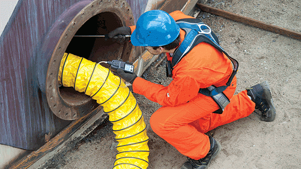 Example of a confined space with a person using a gas monitor to test the air inside