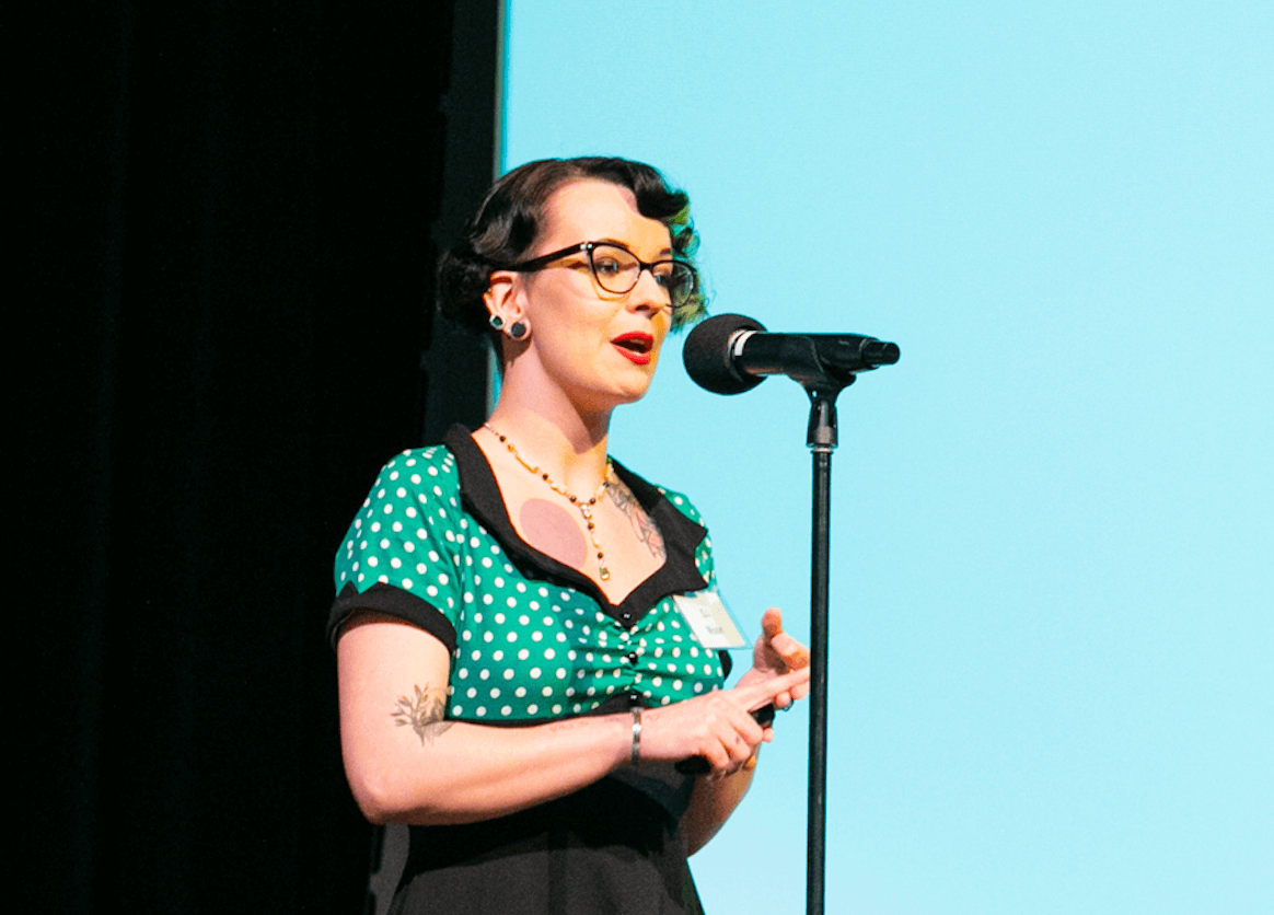 Smiling young woman speaking at a microphone