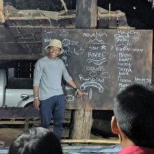 Malachi Chukwu teaches spelling to children in Palong Tribe
