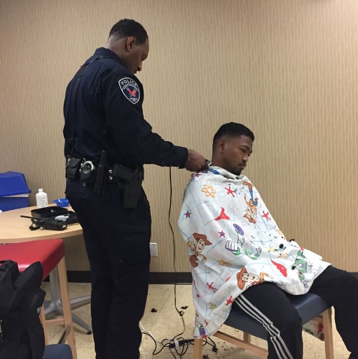 Officer Moore giving students haircuts