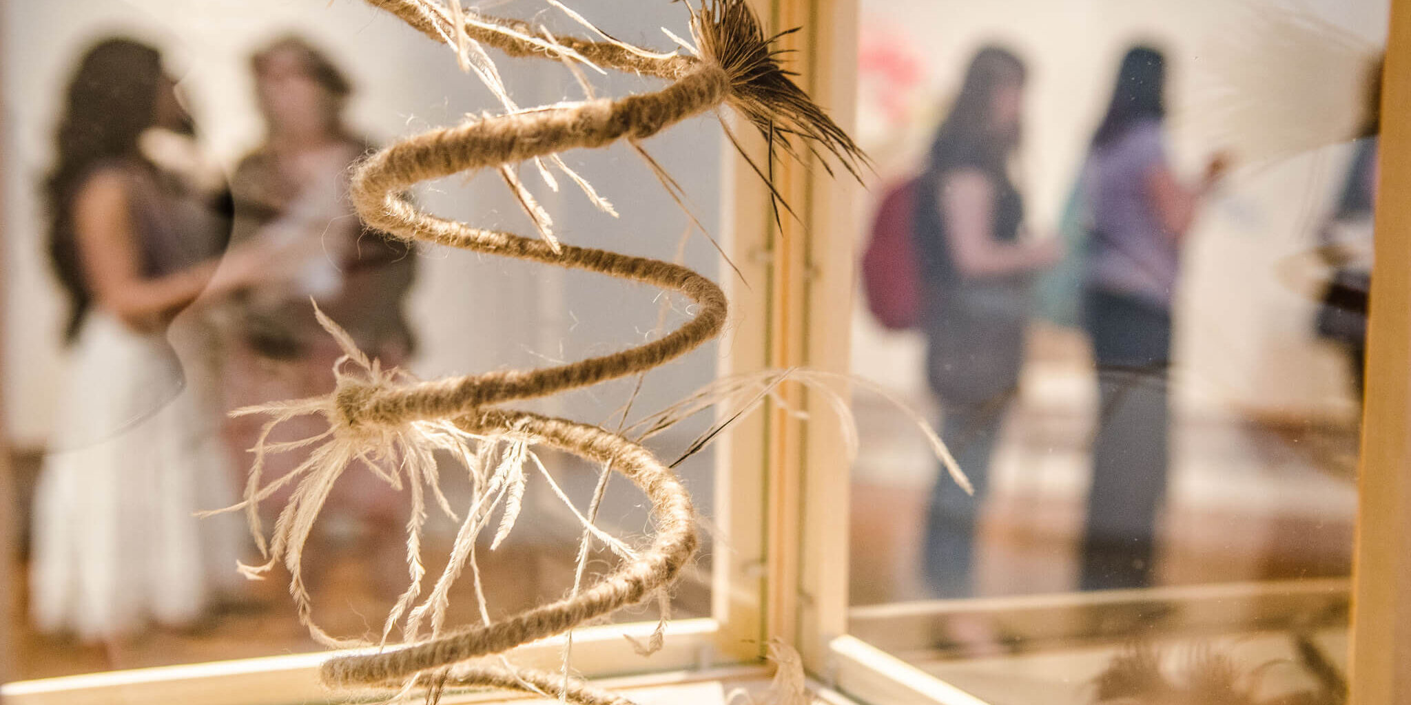 String sculpture with blurred people in background