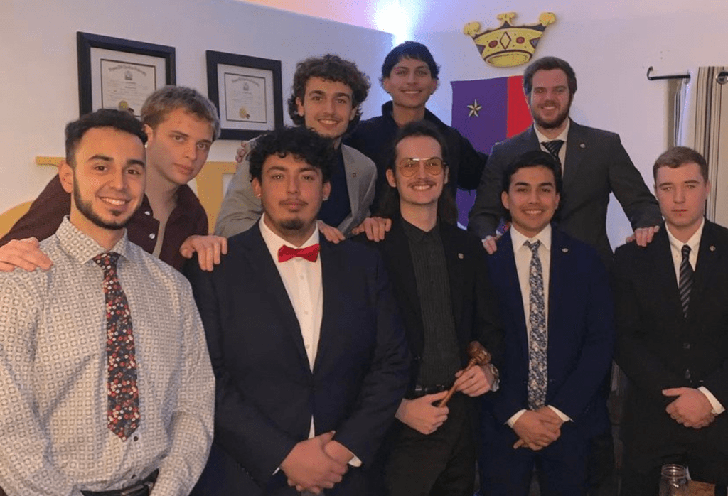 Group of fraternity students in formal wear within their greek house